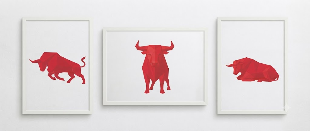 Three white-framed prints of a red geometric bull in charging, standing and resting poses on a light wall